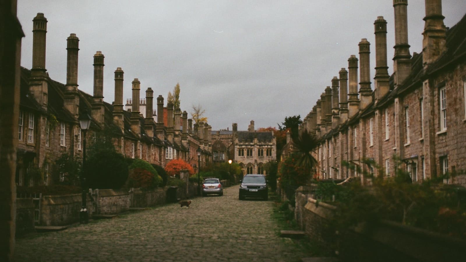 Cobbled street lined with stone terraced houses and tall chimneys